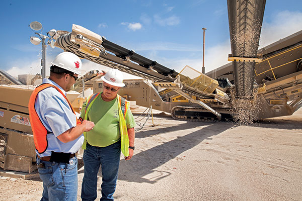 Adam Smith (left), service manager for Texas Bearing Co., talks with Chris Duplooy, plant foreman for CSA Materials.