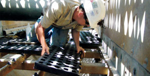 A worker handles modular synthetic media in a middle deck. Photo courtesy of Polydeck